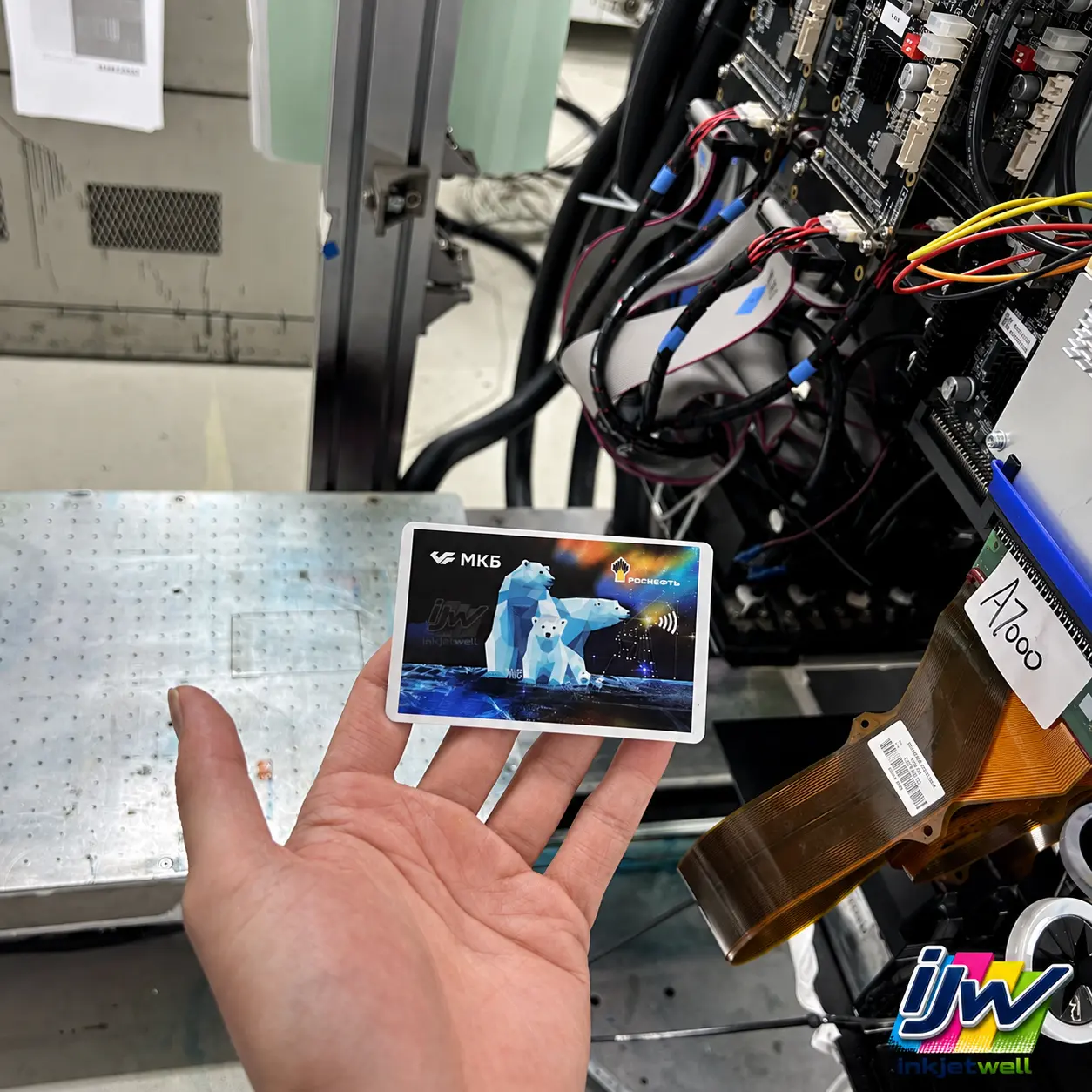 Small full-color electronic-component sample held beside industrial print electronics