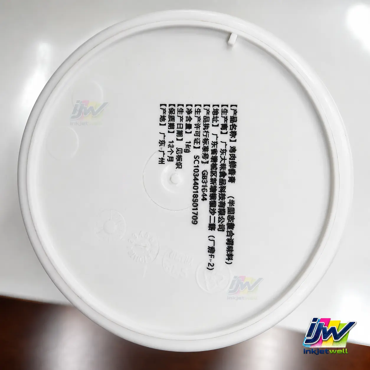 Dense black product information printed directly on the underside of a white plastic lid