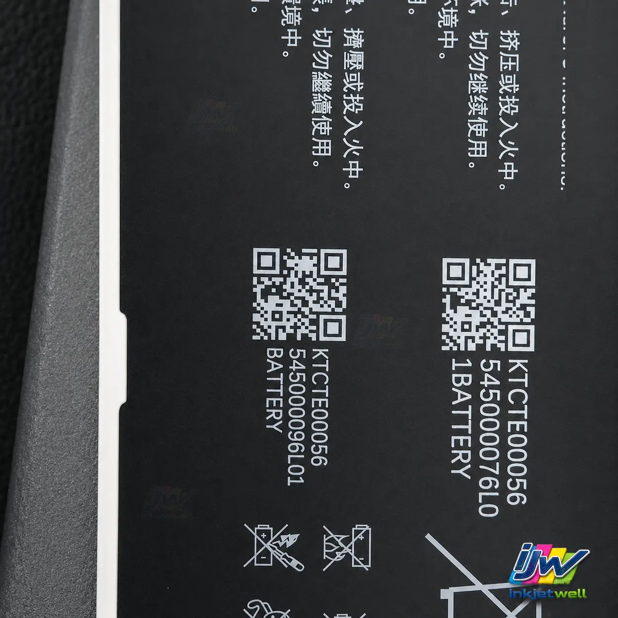 White QR codes, serial numbers and product text printed on a black electronics panel
