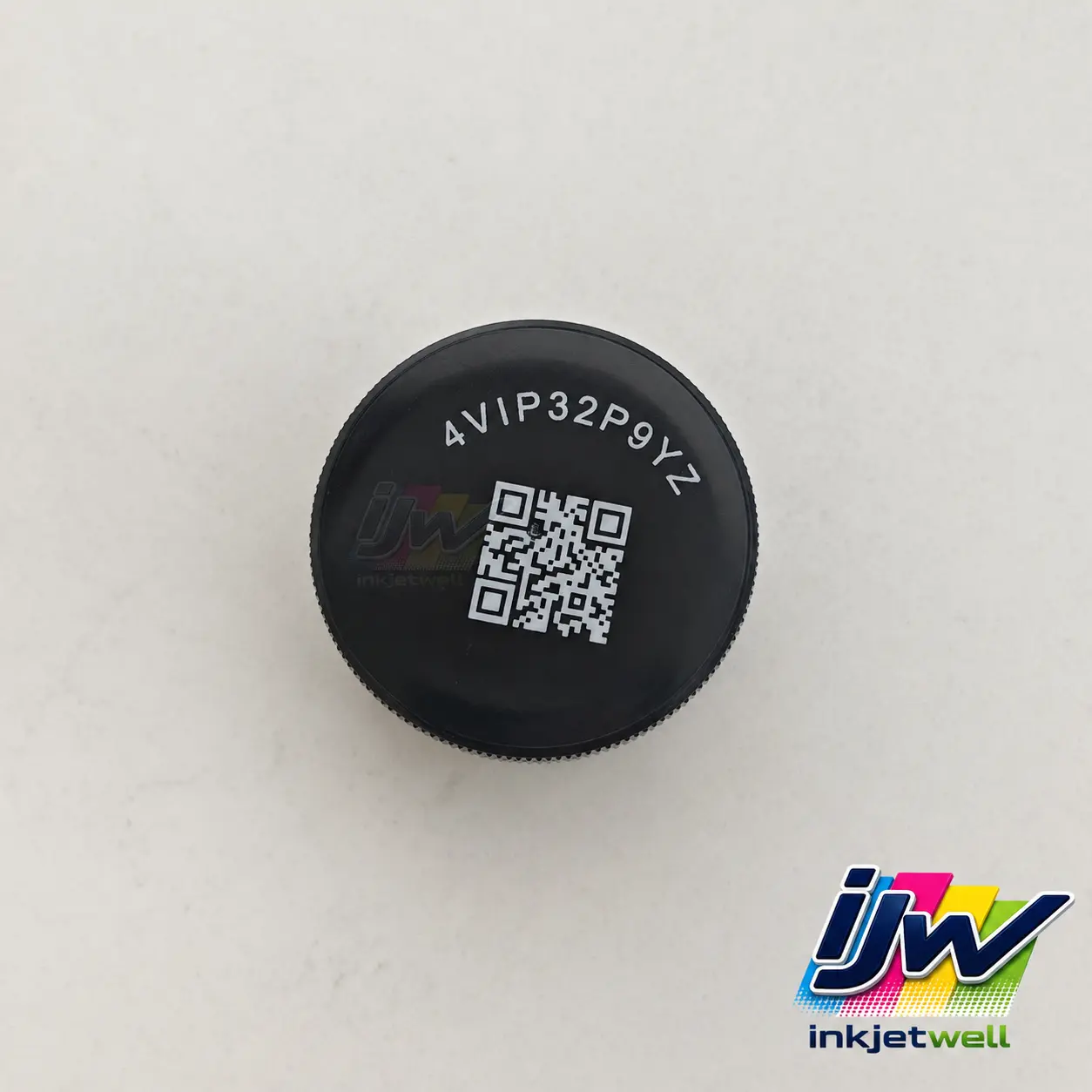 White QR code and alphanumeric identifier printed on a black circular plastic cap